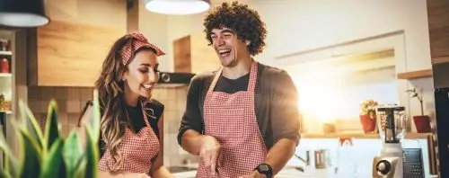 Mann und Frau haben Spa&szlig; beim gemeinsamen Kochen 